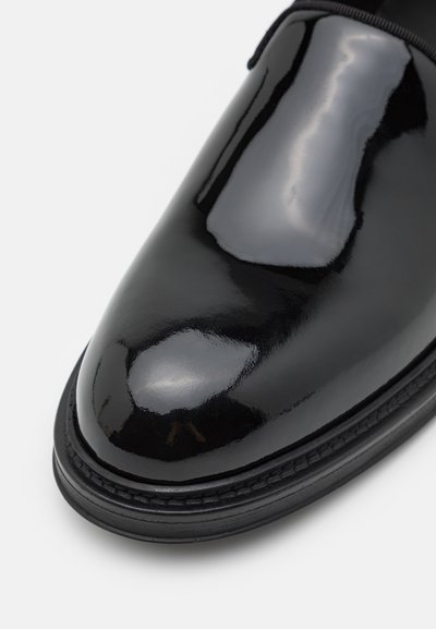 Schwarzer Lackleder-Dressschuh mit glänzender Oberfläche, abgerundetem Zehenbereich und sichtbaren Nähten entlang der Sohle. Glatte Textur und polierte Oberfläche.