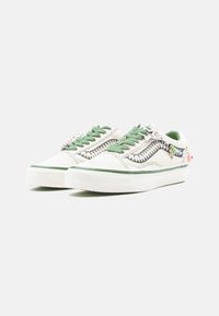 Plátené tenisky s farebnou kombináciou zelenej a bielej, dekoratívnym prešívaním, zelenými šnúrkami a rôznymi príveskami na päte.