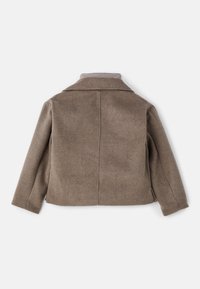 Veste en laine marron texturée avec manches longues, col large et couture centrale visible dans le dos, posée à plat sur un fond blanc.