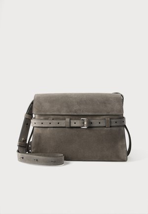 Sivá semišová crossbody taška s nastaviteľným remienkom na pracku a zapínaním na klopu, s jemne vypuklým logom značky v strede vpredu.