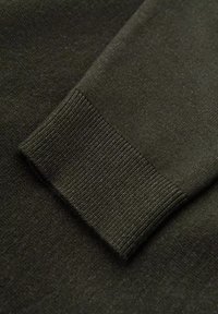 Tessuto a maglia verde scuro con un dettaglio a polsino a coste, texture liscia, cuciture uniformi e una leggera lucentezza. Focus sull'impressione della manica.