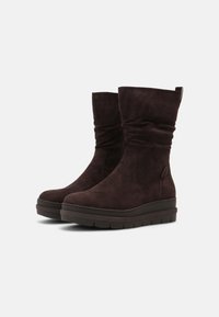 Braune Wildleder-Ankle-Boots mit lässigem Design, rundem Schuhspitze und gepolsteter Plateau-Sohle. Mit einer Zuglasche für einfaches Anziehen.