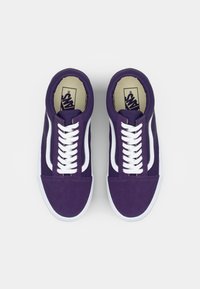 Purple suede sneakers with white laces, featuring a classic low-top design and contrasting white side stripes. Rubber soles are visible.