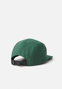 Dark green fabric cap with black adjustable strap and buckle, shown from back and side on a white background.