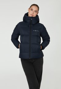 Marineblaue Steppjacke mit hohem Kragen und Frontreißverschluss. Verfügt über horizontale Steppung, Logo auf der Brust und elastische Bündchen.
