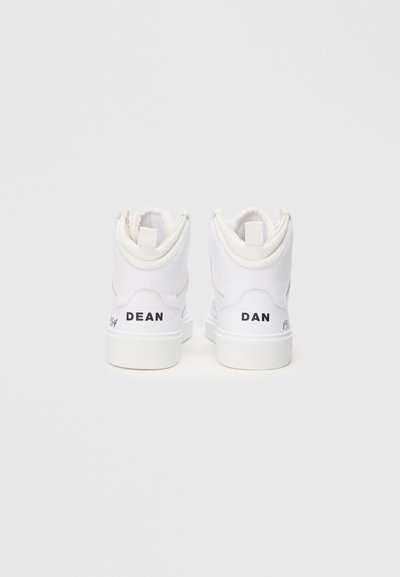 Fehér bőr magas szárú sportcipők sima textúrával. Fekete "DEAN" és "DAN" feliratok az oldalsó sarok részen. Minimalista dizájn.