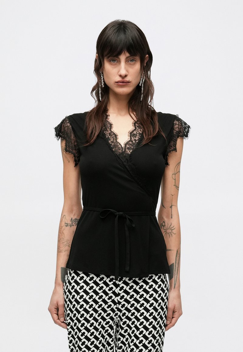 Czarna kopertowa bluzka z krótkimi koronkowymi rękawami, głębokim dekoltem w kształcie litery V i wiązanym paskiem w talii. Gładki materiał z koronkowymi detalami przy dekolcie i rękawach.