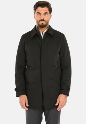 Cappotto nero fino al ginocchio con chiusura a bottoni, colletto appuntito e tasche laterali. Realizzato in tessuto liscio con una texture leggermente lucida.