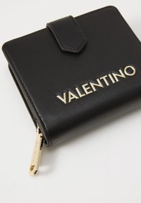 Portafoglio in pelle nera con una finitura testurizzata, dotato di una zip dorata e del logo "VALENTINO" impresso sul fronte.