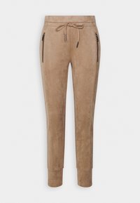 Pantalons joggers beiges en matériau similaire au daim, dotés d'une taille avec cordon de serrage, de deux poches latérales zippées et de manchons fuselés.