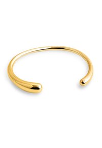 Pulsera de puño de oro, con una superficie lisa y pulida, diseño abierto con extremos redondeados y una estética elegante y minimalista.