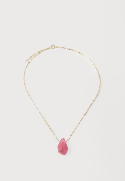 Zlatý náhrdelník s pendantom z ružového, facetovaného drahokamu s viditeľnými inklúziami a nepravidelným tvarom.