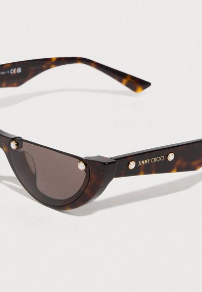 Γυαλιά ηλίου με καβούκι χελώνας, καμπύλο πλαίσιο, σκοτεινούς φακούς, στοιχεία από μαργαριτάρι και λογότυπο "JIMMY CHOO" σε χρυσό στο πλάι.