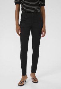 Black tailored pants with a slim fit, featuring a button closure, two front pockets, and side seam detailing. Smooth fabric texture.