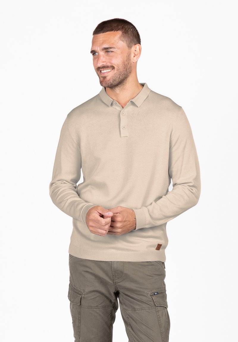 Polo shirt beige a maniche lunghe con colletto, tre bottoni e polsini a costine. Presenta una piccola patch del logo marrone sul lato.