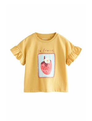 Gelbes Baumwoll-T-Shirt mit gerafften Ärmeln, versehen mit einem gedruckten Erdbeer-Design, eingerahmt von pinken Muschelkanten und dem Text "la Fraise."