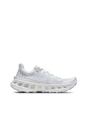 Sneaker atletico bianco con suola spessa e ventilata, tomaia in mesh, design con lacci e motivo geometrico sottile sul tallone, mostrato in profilo laterale.