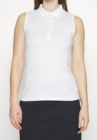Biała bezrękawnik z kołnierzykiem i zapięciem na pięć guzików. Gładki materiał o dopasowanym kroju i subtelny detal logo.