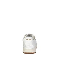 Sneaker bianco in tela con superficie testurizzata, suola in gomma con macchie colorate e accentuazione del tallone posteriore con logo "ACBC" in oro.