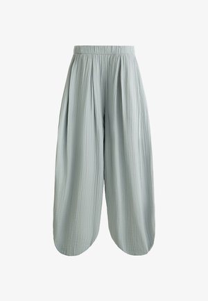 Svetlo zelene široke hlače iz teksturirane, pomaknute tkanine. Imaju nabranu elastičnu pasicu i labav, leteći siluetu.