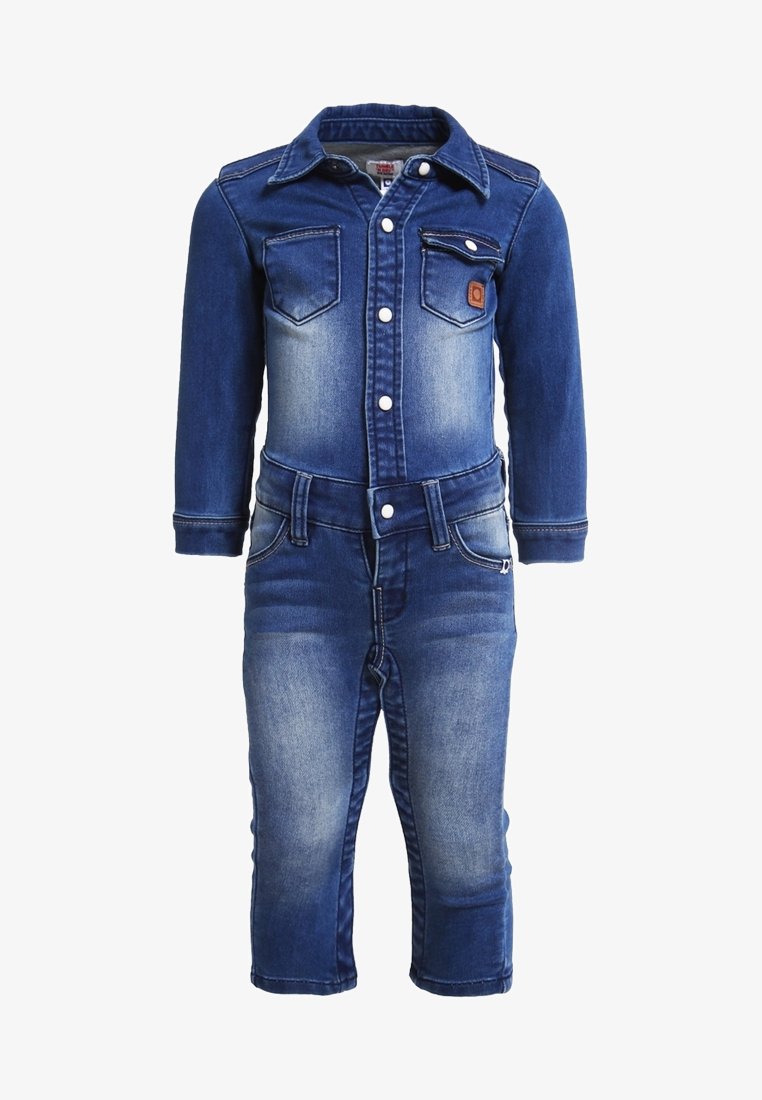 Combinaison en denim avec fermeture à boutons sur le devant, deux poches poitrine et un lavage bleu délavé. Manches longues et jambes fuselées avec détails de couture.