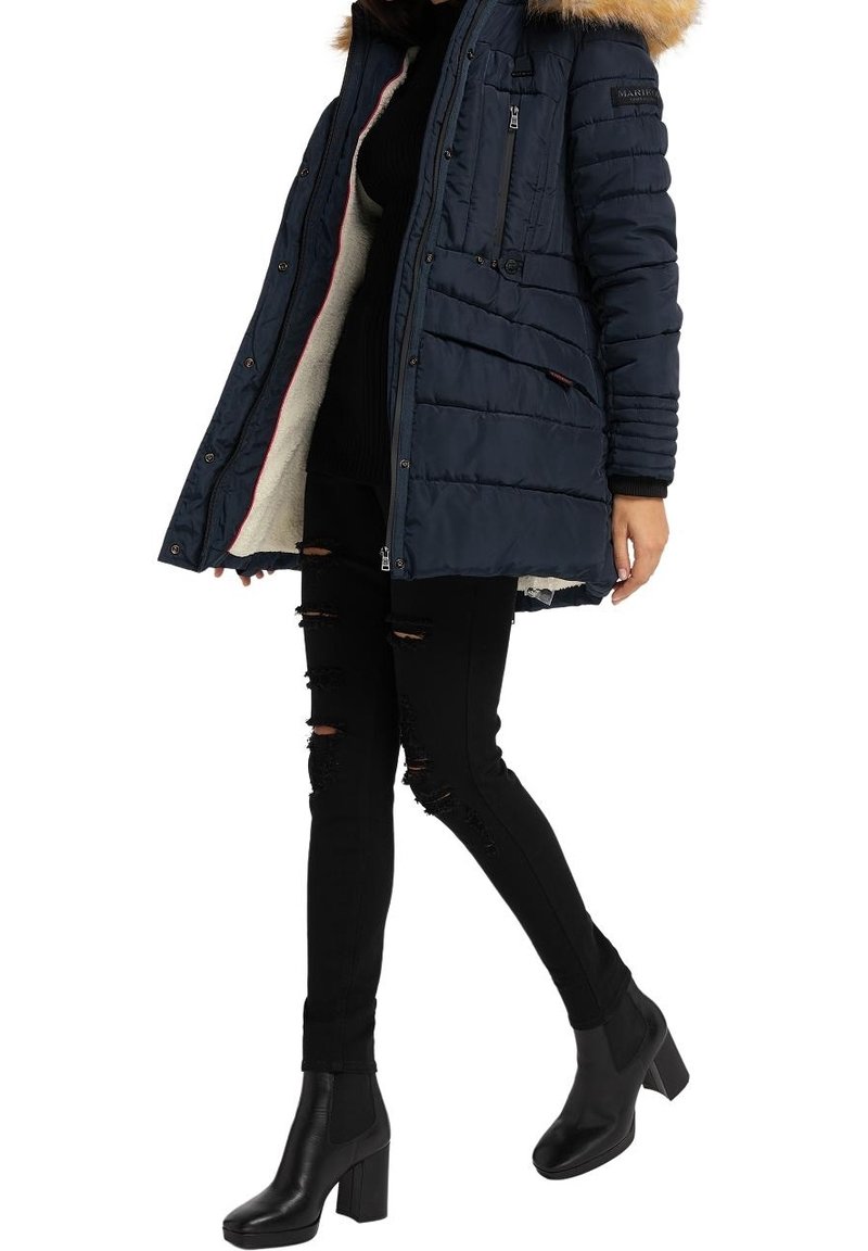 Marinblå puffjacka med en fodrad huva i päls, med dragkedja fram, sidofickor, quiltat mönster och mjukt foder. Bärs med svarta rivna jeans och stövlar.