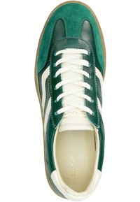 Green suede and leather sneaker with white stripe accents and round toe. Features white laces and a tan rubber sole. Gold logo on the insole.