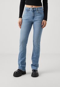 Ljusblå denimjeans med slim fit och lätt utsvängda ben, med hög midja, fem fickor och minimala söms detaljer.