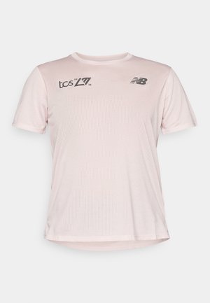 Light pink, short-sleeve athletic t-shirt with mesh texture. Features black branding on the chest and a relaxed fit.