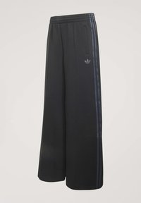Black wide-leg track pants with elastic waistband, side pockets, and dark three stripes running down the sides with a small logo on the thigh.