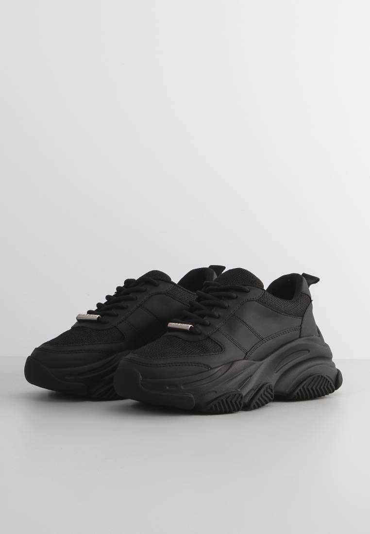 Svarta sneakers med mesh-överkant, tjock gummisulor, snörningsdesign och diskreta metalliska detaljer. Texturerad yta och vadderad krage.