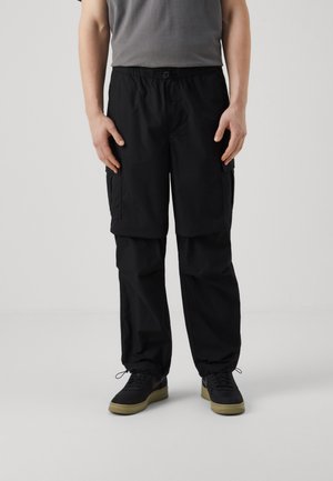 Zwarte cargobroek met een elastische tailleband, zijzakken en een losse pasvorm; gemaakt van lichte stof met een gladde textuur.