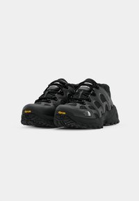 Crne planinarske cipele od mrežastih i gumiranih materijala, Vibram potplati, ojačani vrhovi prstiju i podesive vezice za sigurno pristajanje.