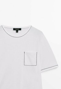 T-shirt blanc à manches courtes avec surpiqûres contrastantes noires au niveau de l'encolure ronde, de la poche poitrine et du bord des manches.