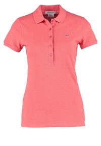 Polo femme rose corail à manches courtes avec patte de boutons et petit logo crocodile brodé sur la poitrine.