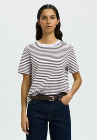 Stripet t-skjorte i hvit og brun, laget av myk stoff, korte ermer, rund hals, sammen med blå denimjeans og et brunt belte.