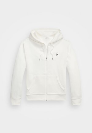 Hvit zip-up hettegenser i myk stoff, med en frontlomme, snorhette, ribbestrikkede mansjetter, og en liten svart logo på brystet.