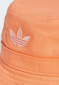 Orange bucket hat made of cotton, featuring a stitched double band and an embroidered logo in a slightly lighter shade.