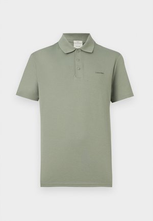 Olivengrøn polo med korte ærmer, tre knapper og lille Calvin Klein-logo på venstre bryst.