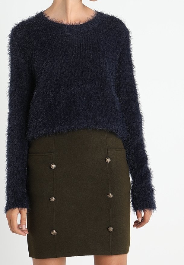 Marineblauer, flauschiger Pullover mit Rundhalsausschnitt, kombiniert mit einem olivgrünen Rock mit fünf Knopfakzenten und Seitentaschen.