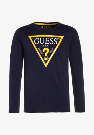 Granatowa koszula z długim rękawem z trójkątnym logo Guess obramowanym na żółto oraz napisem "GUESS U.S.A. Washed Jeans" umieszczonym na środku z przodu.