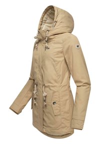 Beige waterproof jacket with a hood, adjustable drawstrings, front pockets, and silver hardware detailing. Smooth texture and mid-length design.