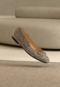 Μπαλαρίνα με μοτίβο λεοπάρδαλης, κατασκευασμένη από ύφασμα με λεία υφή, με στρογγυλεμένη μύτη και μικρό φιόγκο στο μπροστινό μέρος.