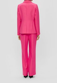 Różowy, dopasowany blezer i spodnie do kompletu, wykonane z gładkiej tkaniny. Garnitur posiada klasyczny kołnierz i prosty krój nogawek.