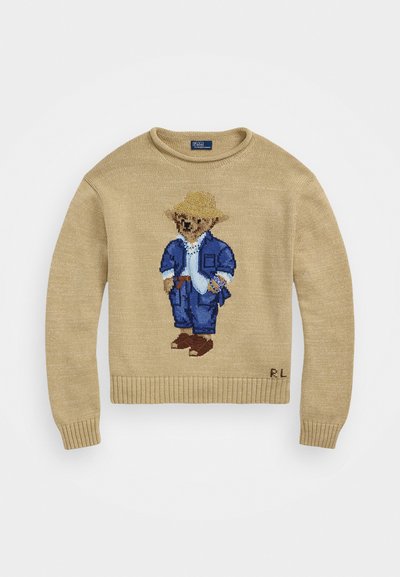 Pulover tricotat bej, cu un urs brodat îmbrăcat în haine albastre și cu o pălărie din paie. Fete cu margini și manșete cu inițialele logo-ului în partea de jos.