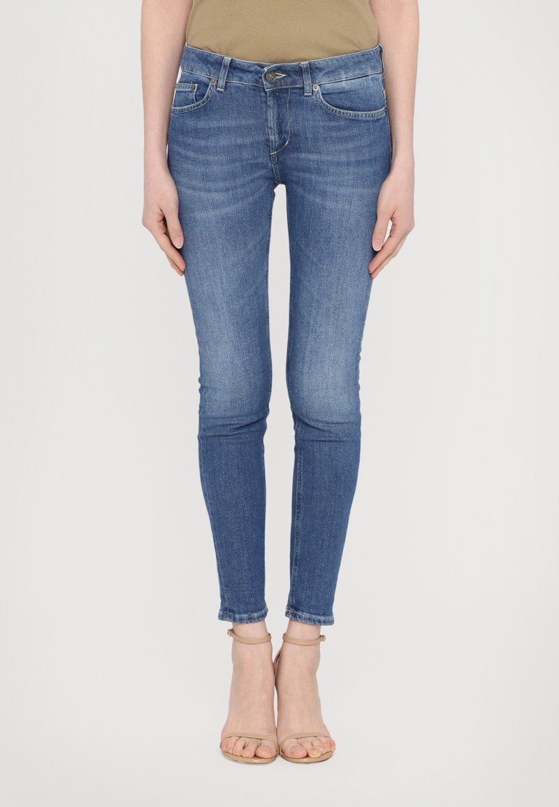 Jeans ajustados en denim azul medio, con un diseño clásico de cinco bolsillos, cierre de cremallera y puños enrollados en el tobillo.