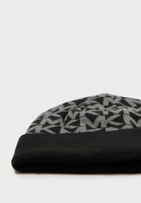Bonnet en tricot noir avec un motif géométrique gris, un revers replié et une texture côtelée, idéal pour les temps froids.