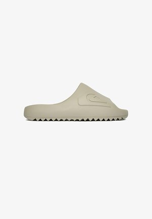 Beige Slip-On-Sandale mit strukturierter Zickzacksohle und einem erhabenen Wellenlogo auf der Oberseite, seitlicher Ansicht.