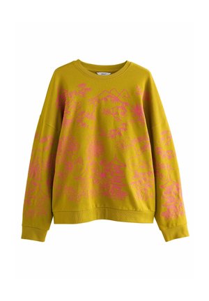 Sweat-shirt jaune moutarde à manches longues avec motifs floraux roses et paysage montagneux sur le devant et les manches.