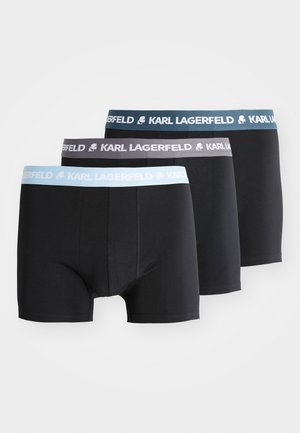 Trois paires de boxers noirs avec des ceintures élastiques. Chaque ceinture arbore le logo "KARL LAGERFELD" en bleu clair, gris et bleu plus foncé.